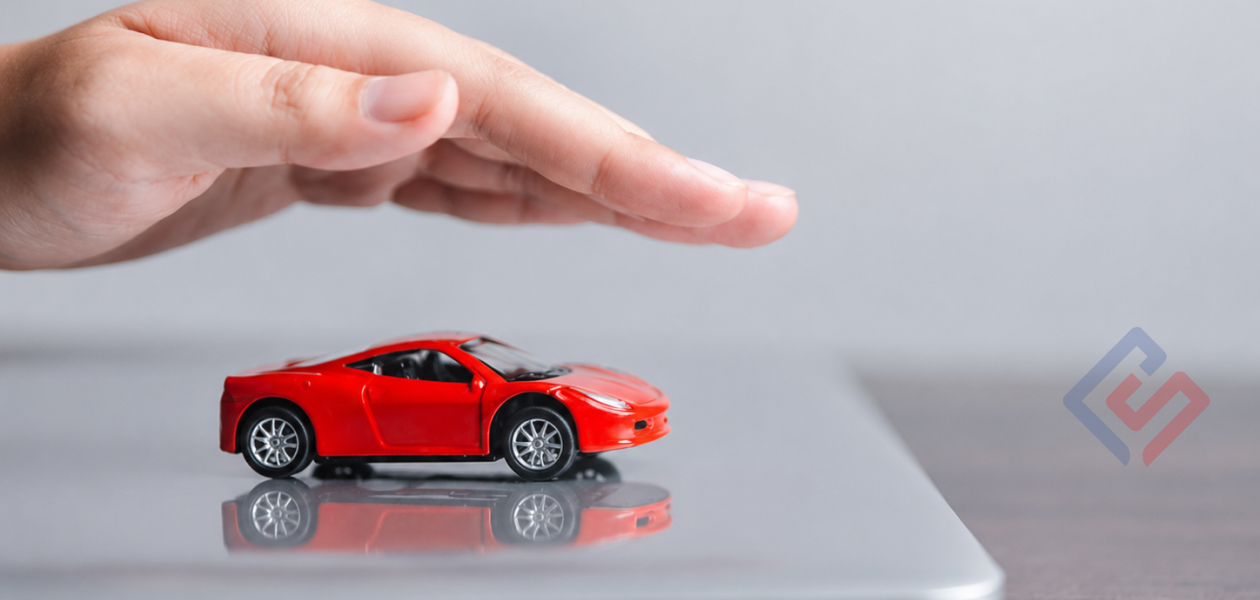 Verificarea poliței RCA online: mână care protejează o machetă roșie de automobil, ilustrație pentru articolul despre valabilitatea și termenul asigurării auto.